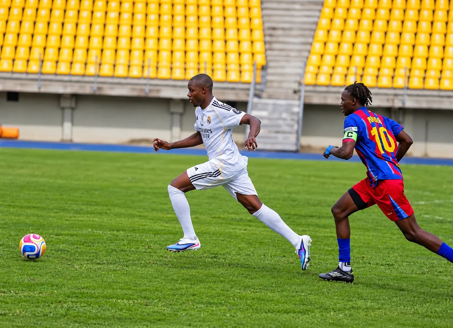 Deux joueurs du Classico Mboa poursuivent le ballon sur le terrain.